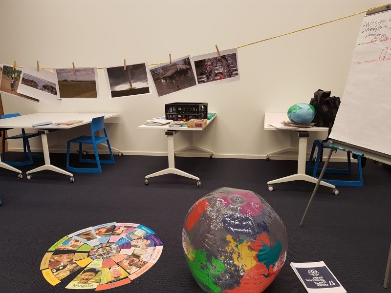 Im Gruppenraum der Bücherhalle Bergedorf hängen Bilder zu den Nachhaltigkeitszielen, es gibt ein Pizza-Diagramm-Spiel und eine Weltkugel.