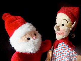 Hier stehen sich zwei Puppen gegenüber: Links der Weihnachtsmann und rechts Kasper.